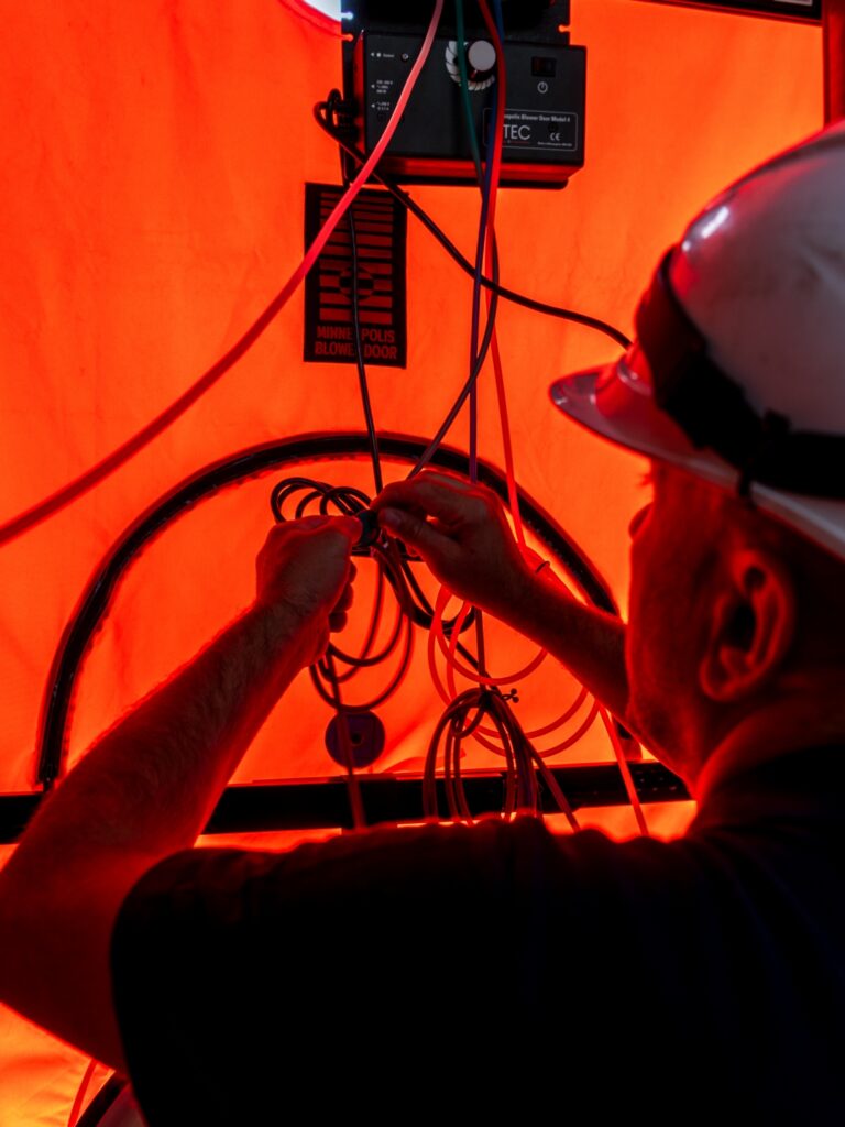 Tècnic realitzant proves de control tèrmic i pressurització per verificar l’eficiència energètica de l’habitatge.
